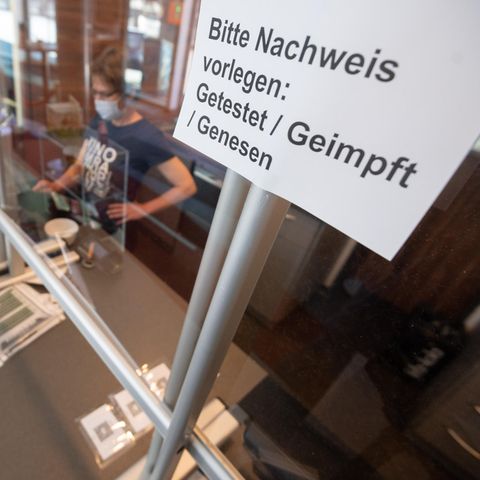 Ein Schild "Bitte Nachweis vorlegen: Getestet, Geimpft, Genesen" hängt an der Kasse von einem Kino 