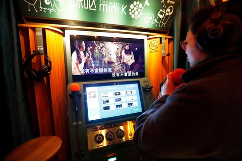 Ein Chinese singt in einer Mini-Karaoke-Kabine im Untergeschoss eines Einkaufszentrums in Shanghai