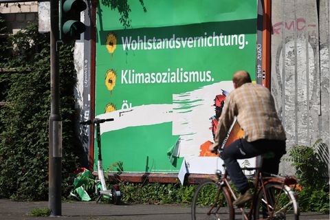 Fahrradfahrer passiert ein Plakat der Negativ-Kampagne