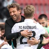 Augsburg Trainer Weinzierl umarmt freudig einen Spieler