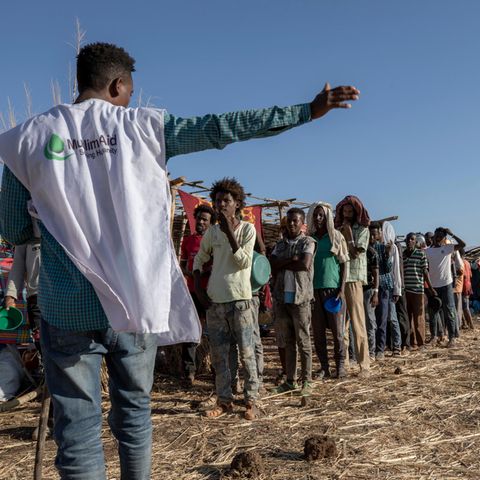 Ein Mitarbeiter einer muslimischen Hilfsorganisation koordiniert die Ankunft von Flüchtlingen in einem Camp nahe der äthiopisch-sudanesischen Grenze