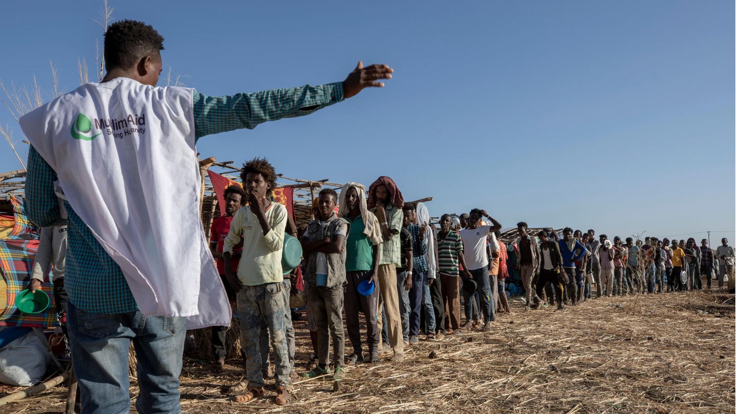 Ein Mitarbeiter einer muslimischen Hilfsorganisation koordiniert die Ankunft von Flüchtlingen in einem Camp nahe der äthiopisch-sudanesischen Grenze