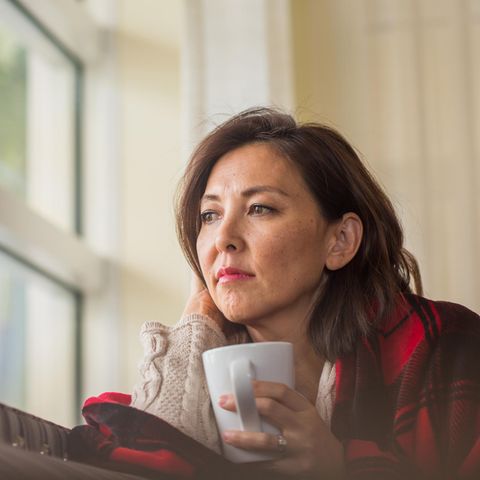 Frau grübelt am Fenster
