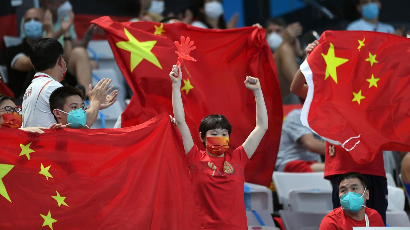 Zuschauer jubeln bei den Olympischen Spielen mit chinesischen Flaggen
