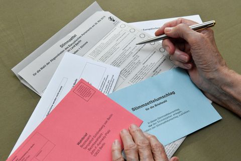 Briefwahlunterlagen werden von älterer Person ausgefüllt