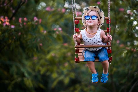 Sonnenbrillen für Kinder: Junge schaukelt mit Sonnenbrille