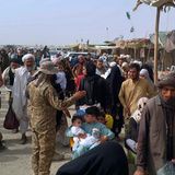 Pakistanische Soldaten überprüfen die Papiere von Menschen, die die Grenze zu Afghanistan an einem Grenzübergang überqueren.