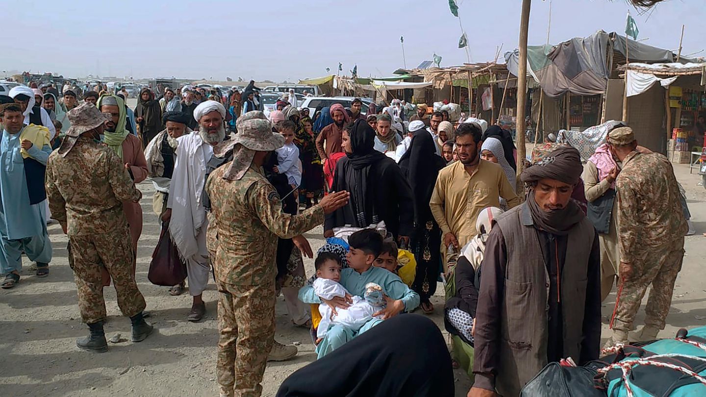 Pakistanische Soldaten überprüfen die Papiere von Menschen, die die Grenze zu Afghanistan an einem Grenzübergang überqueren.