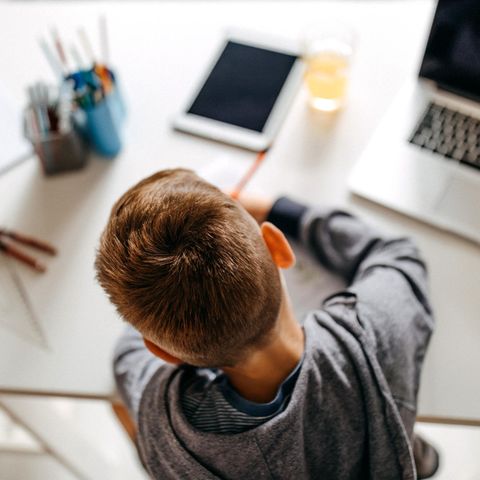 Ein Junge sitzt am Schreibtisch und löst Schulaufgaben