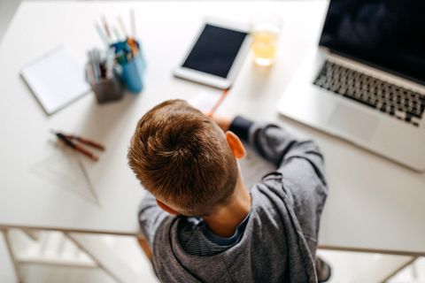 Ein Junge sitzt am Schreibtisch und löst Schulaufgaben