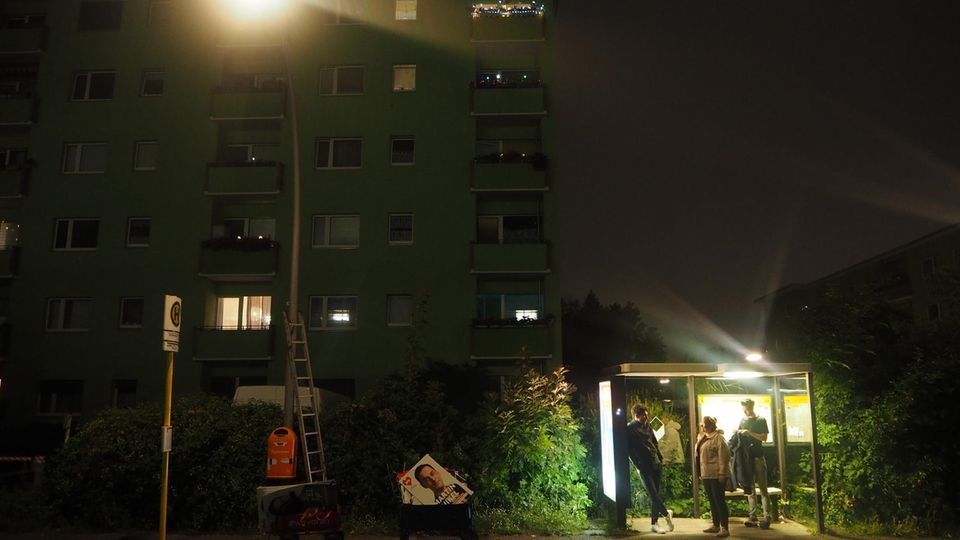 Ein Plakatier-Teams der Neuköllner SPD sucht Schutz in einer Bushaltestelle.