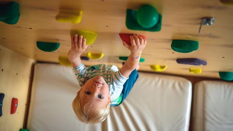 Klettersteine: Junge klettert an Indoor-Kletterwand