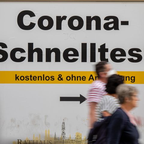 Bayern, München: Ein Schild weist am Rathaus den Weg zu kostenlosen Corona-Schnelltests 