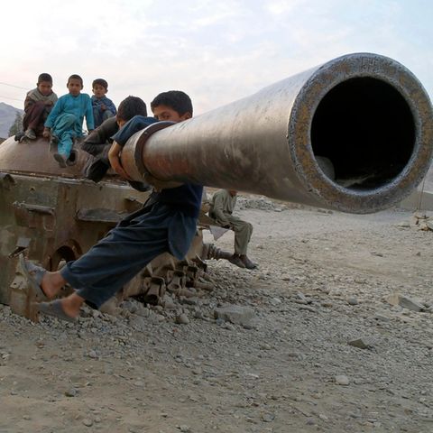 Kinder spielen auf einem alten sowjetischen Panzer in Behsood, Afghanistan