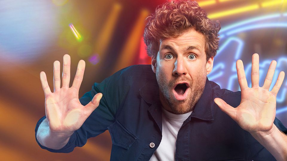 Luke Mockridge schaut in die Kamera und hält die Hände nach vorne