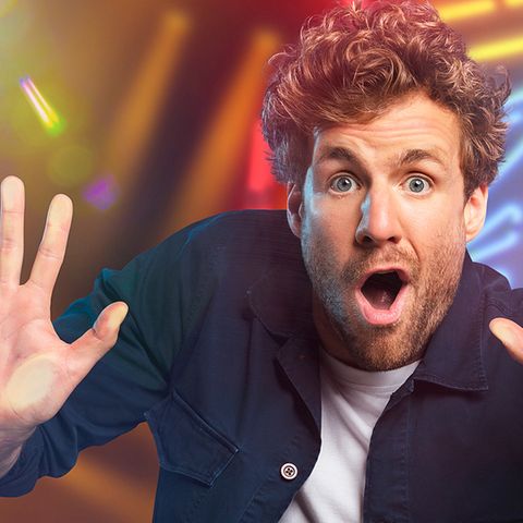 Luke Mockridge schaut in die Kamera und hält die Hände nach vorne