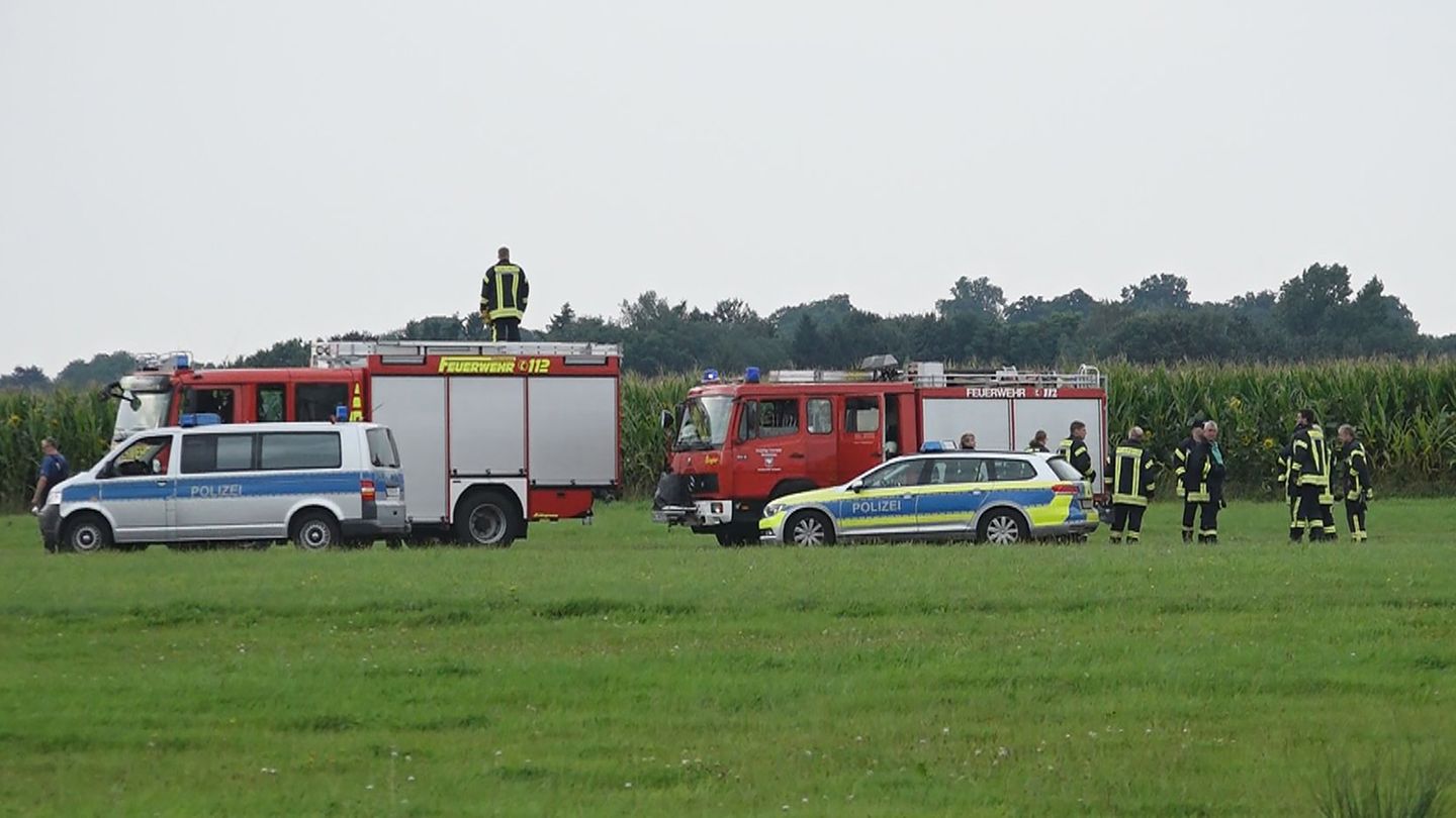 Einsatzkräfte am Rande des Maisfeldes, in dem ein Fallschirmspringer tödlich verunglückte