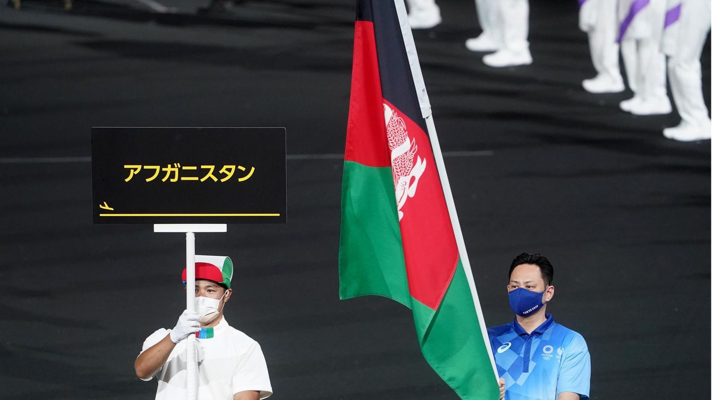 Fahne Afghanistans wird ins Tokioter Olympiastadion geführt