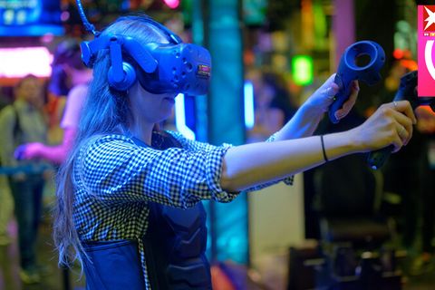 Eine Besucherin testet auf der Gamescom mit einer VR-Brille ein Computerspiel