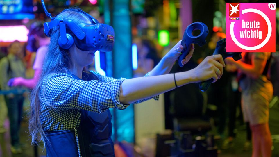 Eine Besucherin testet auf der Gamescom mit einer VR-Brille ein Computerspiel