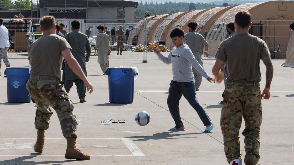 Ein Junge aus Afghanistan spielt mit US-Soldaten Fußball auf der Ramstein Air Base in Rheinland-Pfalz 