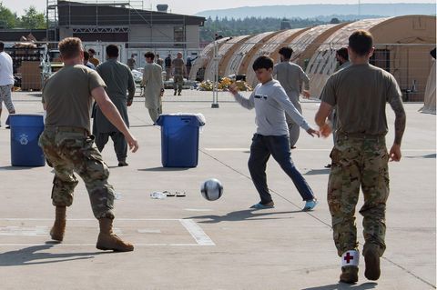 Ein Junge aus Afghanistan spielt mit US-Soldaten Fußball auf der Ramstein Air Base in Rheinland-Pfalz 