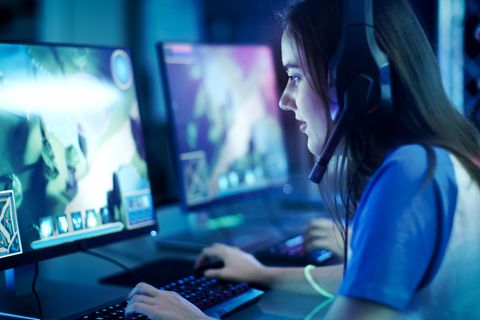 Eine Frau sitzt vorm 240 Hz Monitor und zockt.