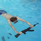 Mateusz übt das Schwimmen mit einer Waffe in einem Sommer-Militärlager im polnischen Mrzeżyno. Die Organisatoren behaupten, dass die Teilnahme mit Waffennachbildungen Kinder daran hindert, echte Waffen zu suchen.