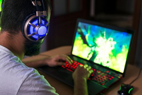 Ein Mann sitzt vor einem Laptop und spielt daran