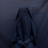 Platz zwei in der Kategorie Zeitgeschehen Stories belegt die amerikanische Fotojournalistin Maya Alleruzzo. Ihre Reihe porträtiert das Leben jesidischer Frauen, die den Anschlag der Terrorgruppe Islamischer Staat (IS) 2014 in der irakischen Grenzregion zu Syrien überlebt haben. Das Bild zeigt die vollverschleierte Layla Taloo und ihre Kleidung, die sie während ihrer Versklavung durch den IS tragen musste. 2014 hatte die islamistische Bewegung die jesidischen Gemeinden im Norden des Irak angegriffen und Frauen und Kinder versklavt. Die UN bezeichnet die Angriffe gegen die Minderheit als Genozid.