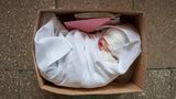 Fertig zur Adoption: Eine frisch gefertigte Babypuppe liegt bereit, um an ihre neuen "Eltern" geschickt zu werden. Das Paket beinhaltet eine Geburtsurkunde und ein Set Baby-Kleidung. Für die "Eltern" ist der Moment des Entpackens etwas ganz Besonderes. Viele filmen das Ereignis, um es in den sozialen Medien zu teilen.