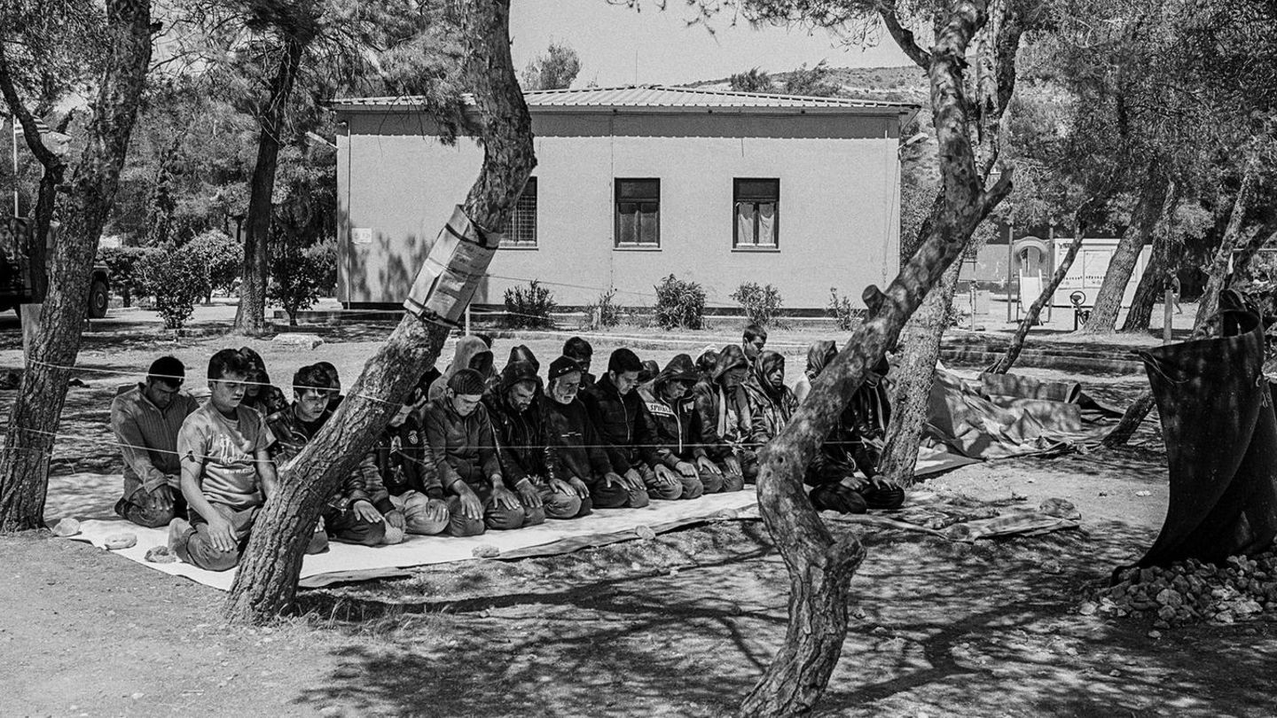 Männer beten unter den Bäumen im Flüchtlingscamp in Schisto, nahe der griechischen Hauptstadt Athen.