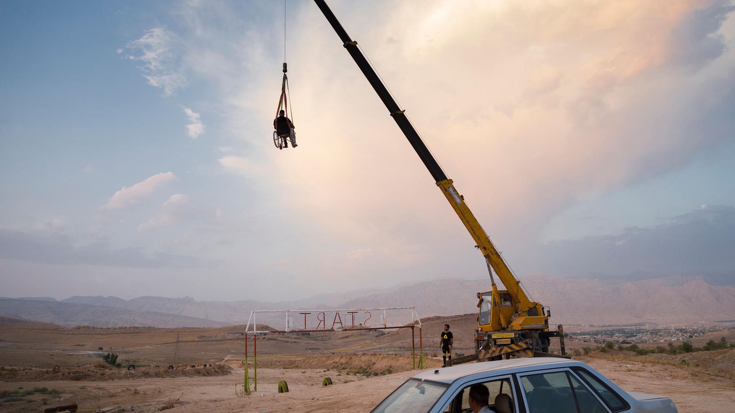 Ein Jahr vor seiner Verletzung brach Saeed den iranischen Rekord für das Springen über eine Luftbrücke über Asphalt. Hier genießt Saeed es, von einem Kran hochgehoben zu werden, während er im Rollstuhl sitzt.