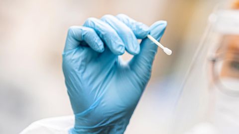 Inzidenz RKI Wochenbericht: Eine Frau in einem Corona-Testzentrum