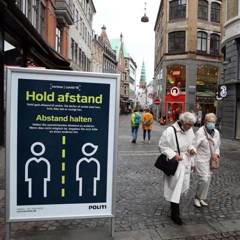 Masken und Schilder, die zum Abstandhalten aufrufen