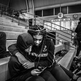 Dion Brown, ein Juniorenspieler der Flint Jaguars, sitzt mit seiner Freundin Lakenya Thomas in einer fast leeren Turnhalle während eines Junioren-Uni-Spiels am 24. Februar 2020.