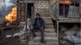 Areg sitzt am 25. November 2020 vor einem brennenden Haus im Dorf Karegach, Berg-Karabach. Einige Dorfbewohner haben ihre Häuser niedergebrannt, bevor sie die Gebiete verlassen haben, die nach dem Friedensabkommen vom November wieder unter aserbaidschanische Kontrolle gestellt werden sollten.