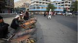 Verkäufer warten am Straßenrand auf Kundschaft. Bewohner von Kabul sprechen von einem insgesamt ruhigen Tagesbeginn in der afghanischen Hauptstadt. So seien etwa die meisten Geschäfte im Stadtteil Schahr-e Nau geöffnet, hätten aber kaum Kunden.