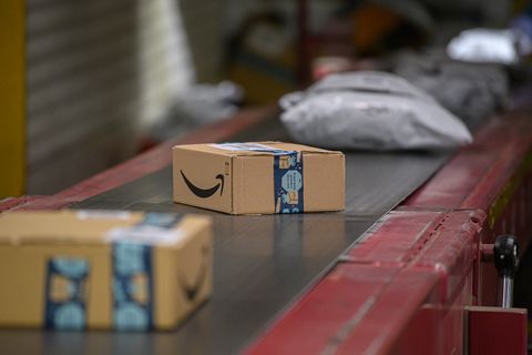 Amazon Pakete liegen im DHL-Paketzentrum auf einem Transportband.