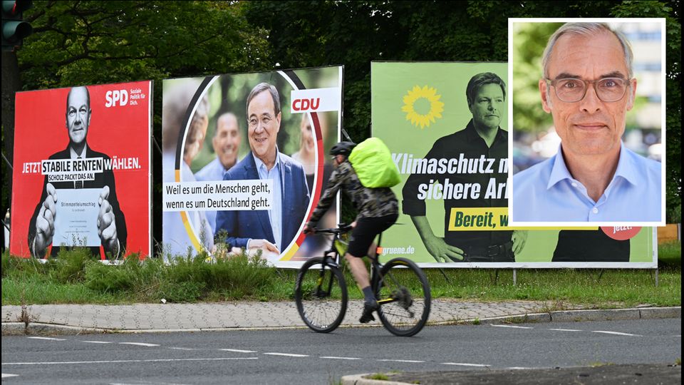 Ein Radfahrer fährt an großen Wahlplakaten mit den Spitzenkandidaten der Bundestagswahl vorbei