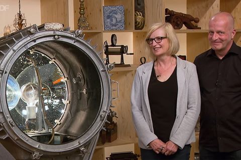 Ellen Behrens und Frank Fohler stehen im Stidio von Bares für Rares neben ihrem Scheinwerfer