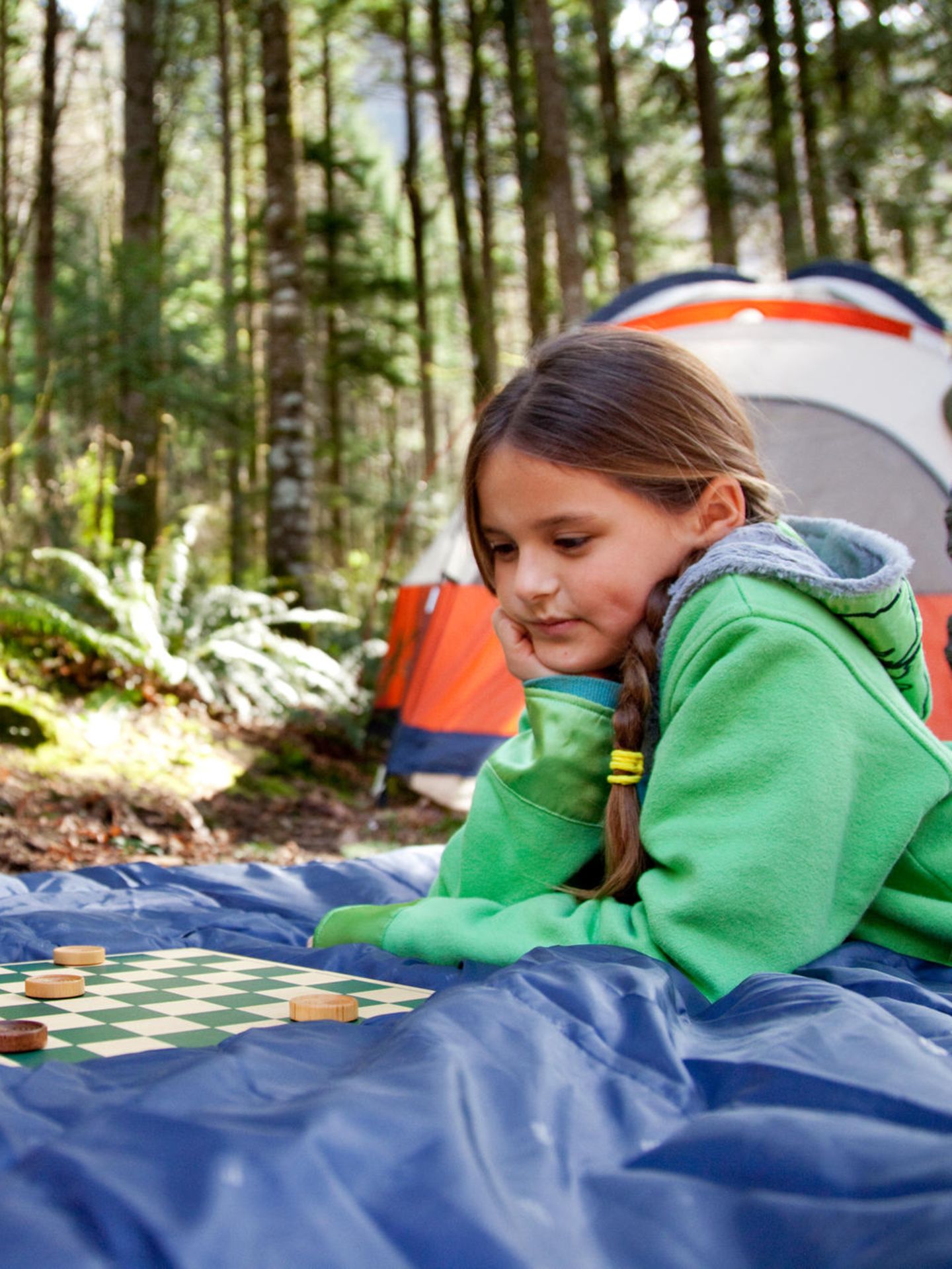Zwei Kinder spielen ein Brettspiel im Freien