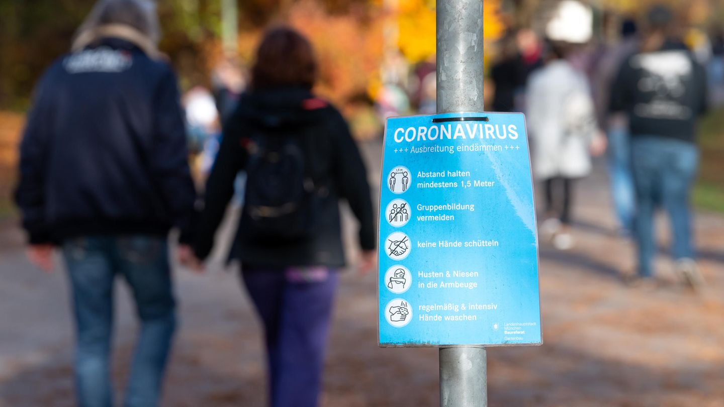 Ein Plakat mit Informationen über das Coronavirus ist an einem Weg im Westpark zu sehen