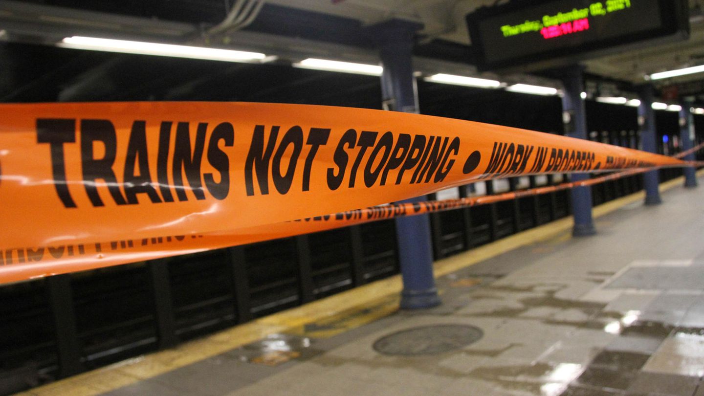 Ein oranges Absperrband mit schwarzer Schrift informiert auf einem Metro-Bahnsteig darüber, dass Züge hier nicht halten Ein oranges Absperrband mit schwarzer Schrift informiert auf einem Metro-Bahnsteig darüber, dass Züge hier nicht halten