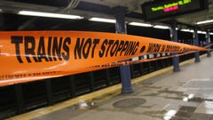 Ein oranges Absperrband mit schwarzer Schrift informiert auf einem Metro-Bahnsteig darüber, dass Züge hier nicht halten