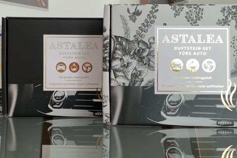 Die drei Versionen des Astalea-Duftsteins aus "Die Höhle der Löwen" stehen in der Verpackung auf einem Tisch.