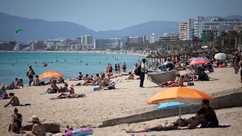 Menschen liegen in der Sonne an einem Strand