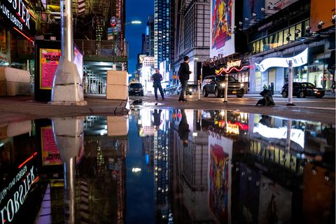 Die Neon-Reklamen des Times Square spiegeln sich in einer riesigen Pfütze