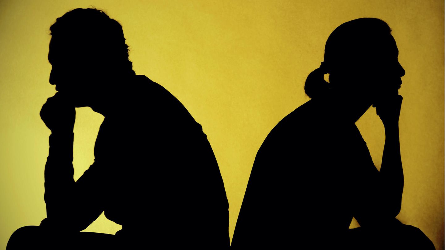 Mann und Frau im Profil sitzen voneinander abgewandt