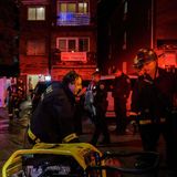 Ein Feuerwehrmann in Uniform beugt sich über eine Motorpumpe mit gelbem Schutzrahmen, ein zweiter schaut ihn an